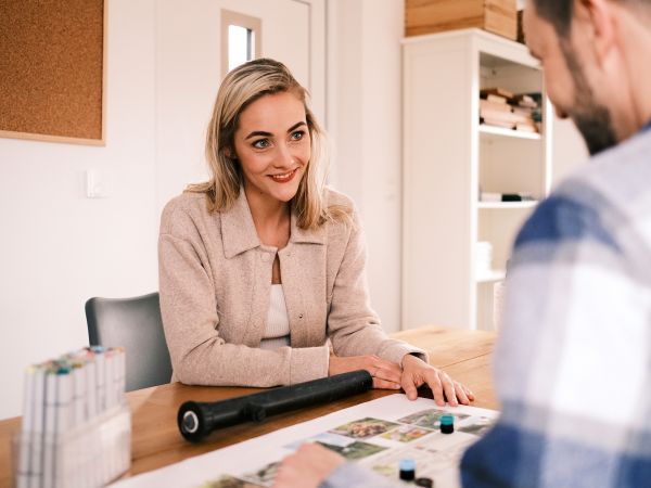 Zwei Personen sitzen an einem Tisch und besprechen etwas
